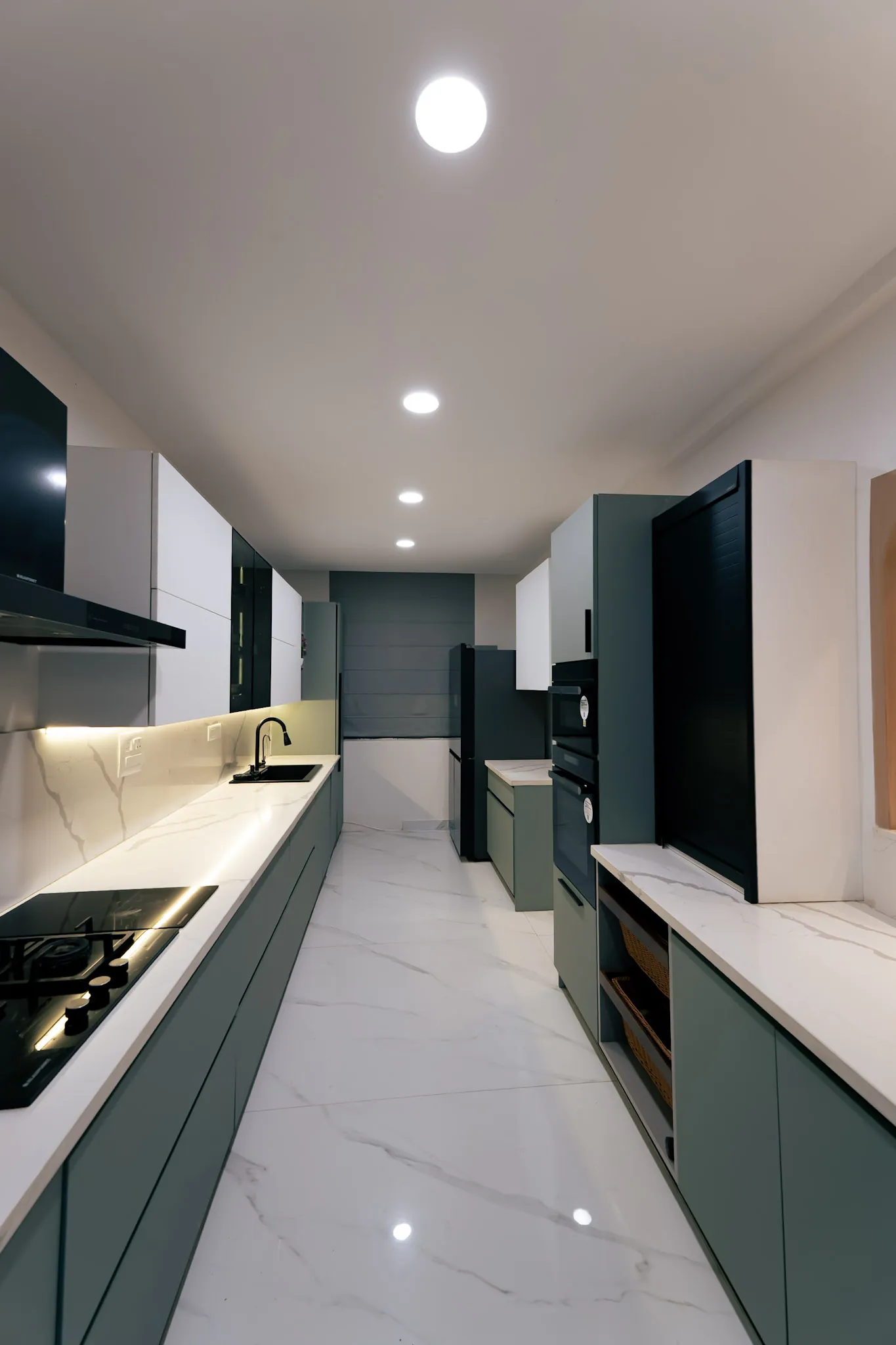 Sage-green galley modular kitchen with hob, chimney and tall appliance units, villa at SVS Silver Oaks, Heelalige