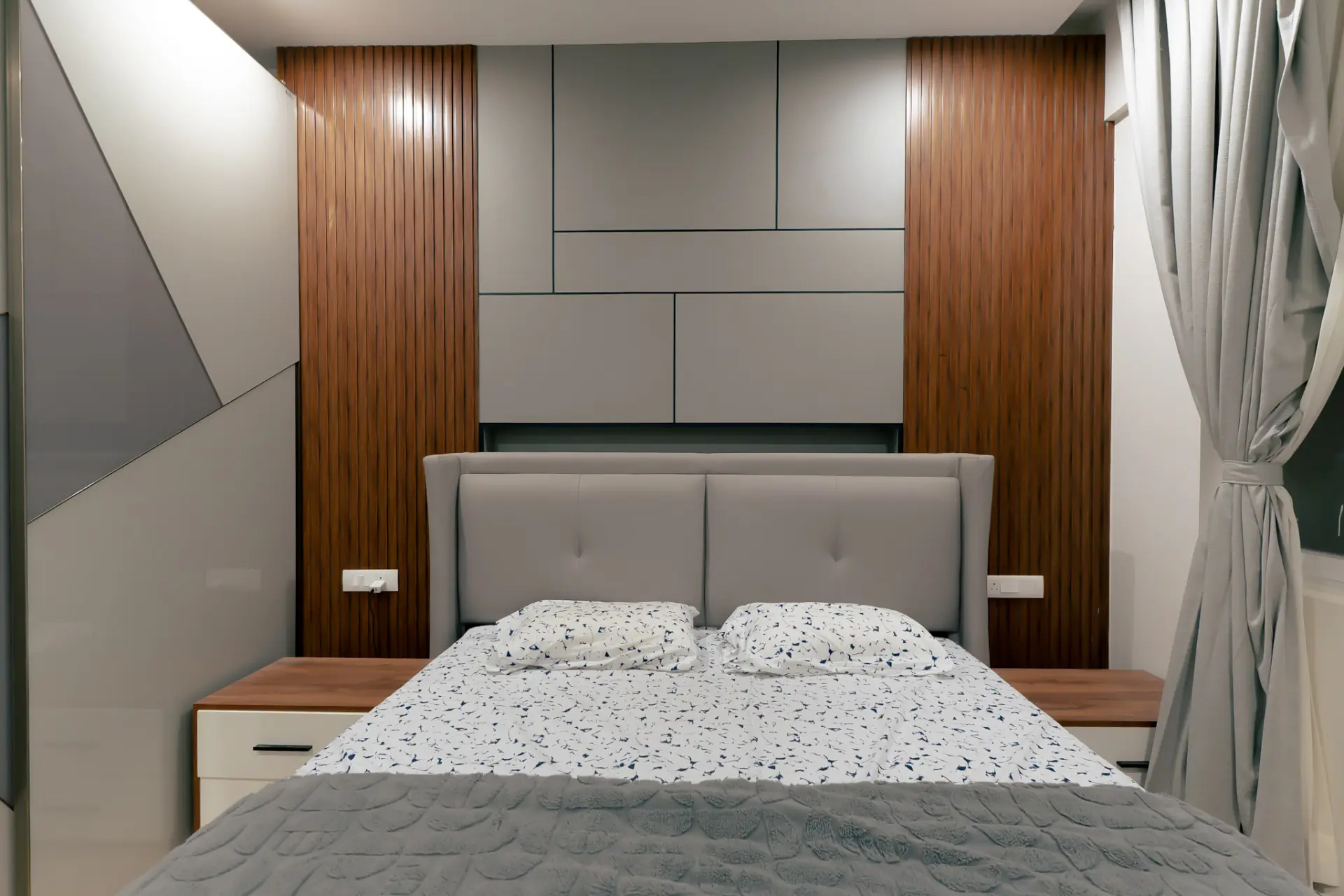 Bedroom with grey upholstered headboard wall and walnut fluted panelling, villa at SVS Silver Oaks, Heelalige