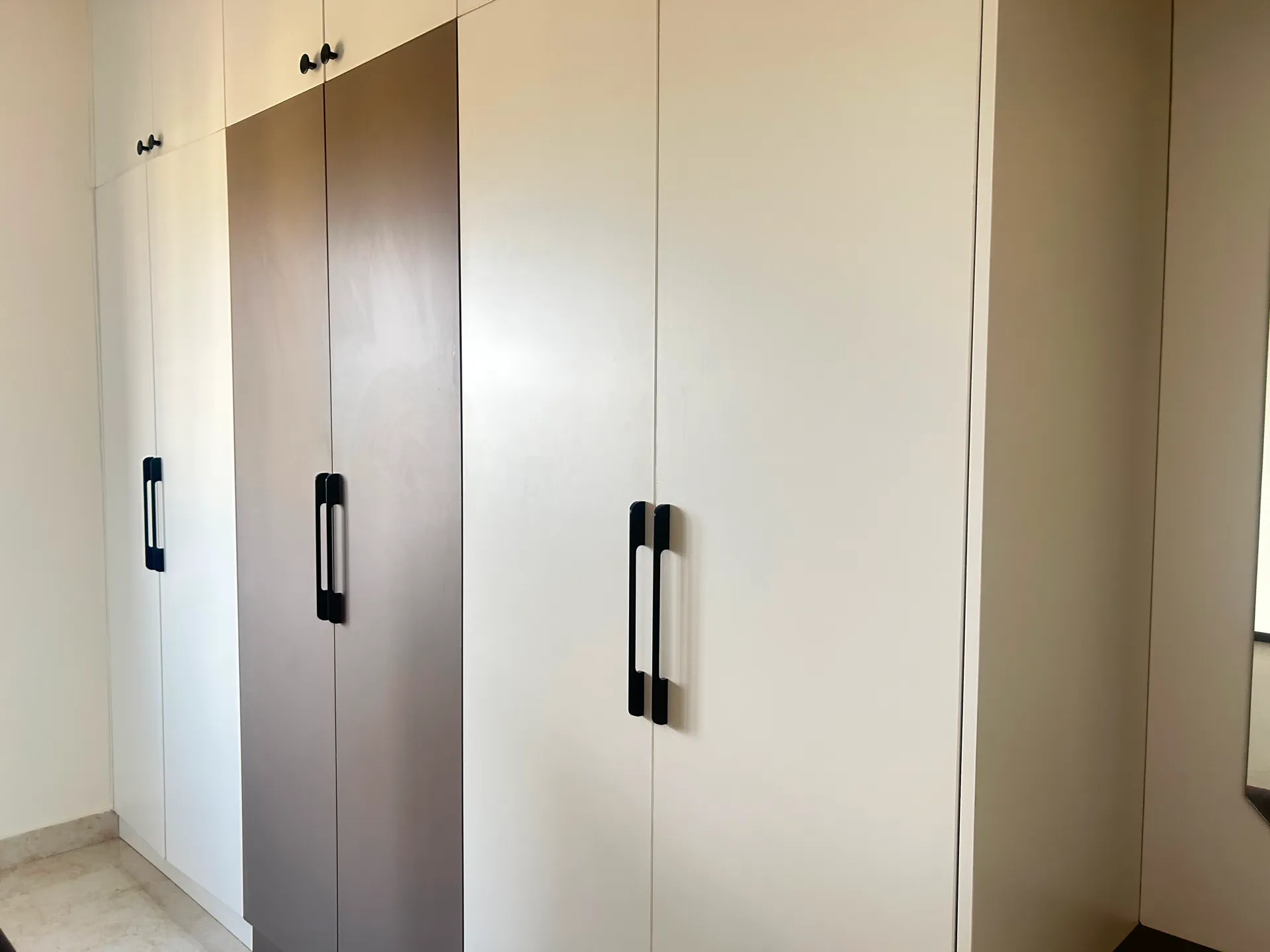 Two-tone swing-door wardrobe with black bar handles — completed Elvenwood project
